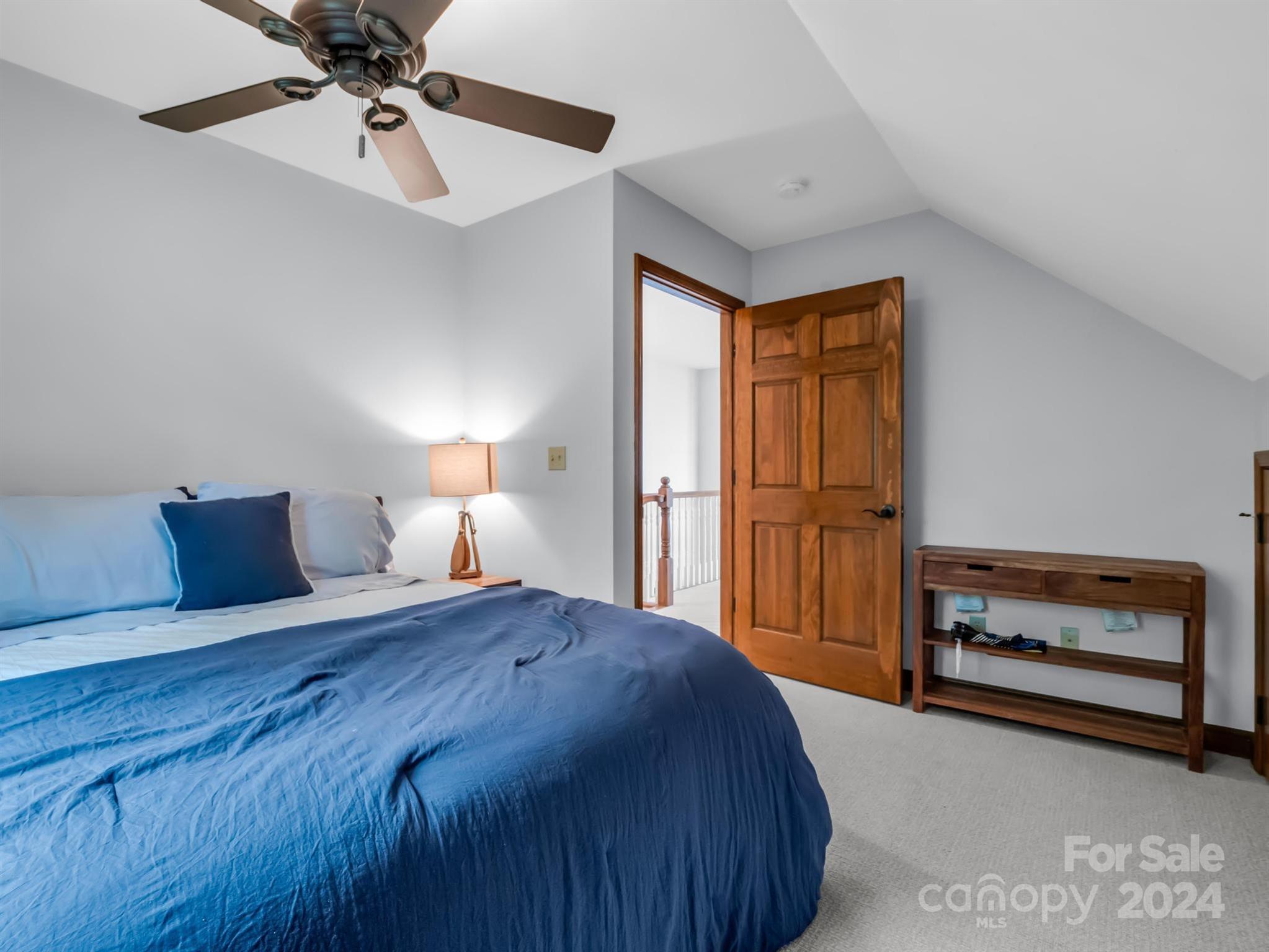 428 Devils Hole Road, Unit 14 Rosman, NC 28772 - Photo 28 of 47 a bedroom with a bed and a lamp