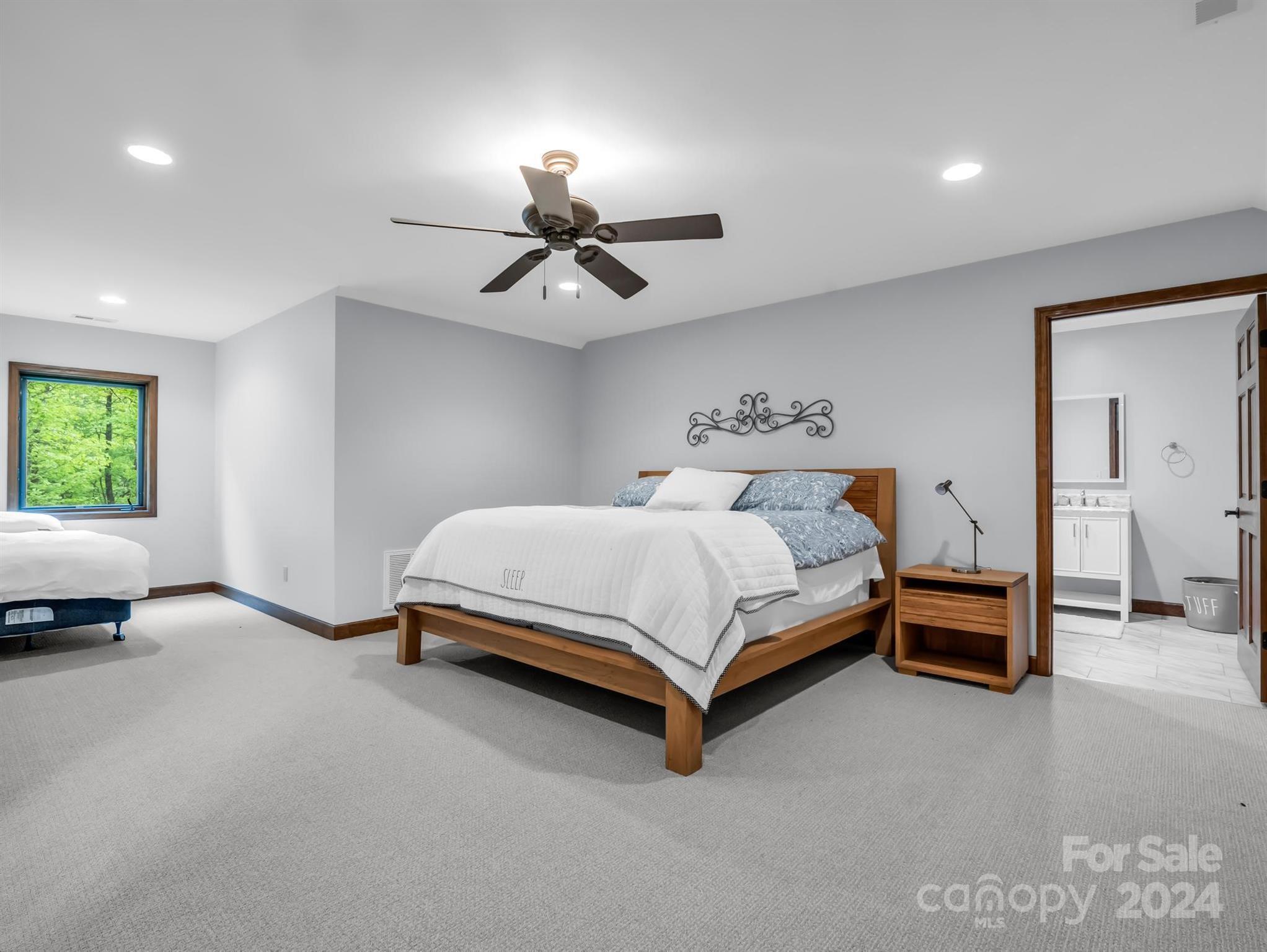 428 Devils Hole Road, Unit 14 Rosman, NC 28772 - Photo 33 of 47 a bedroom with a bed and a chandelier