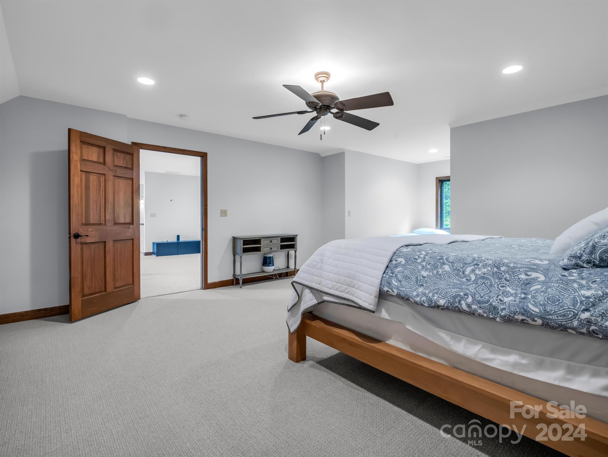 428 Devils Hole Road, Unit 14 Rosman, NC 28772 - Photo 34 of 47 a spacious bedroom with a bed and a chandelier