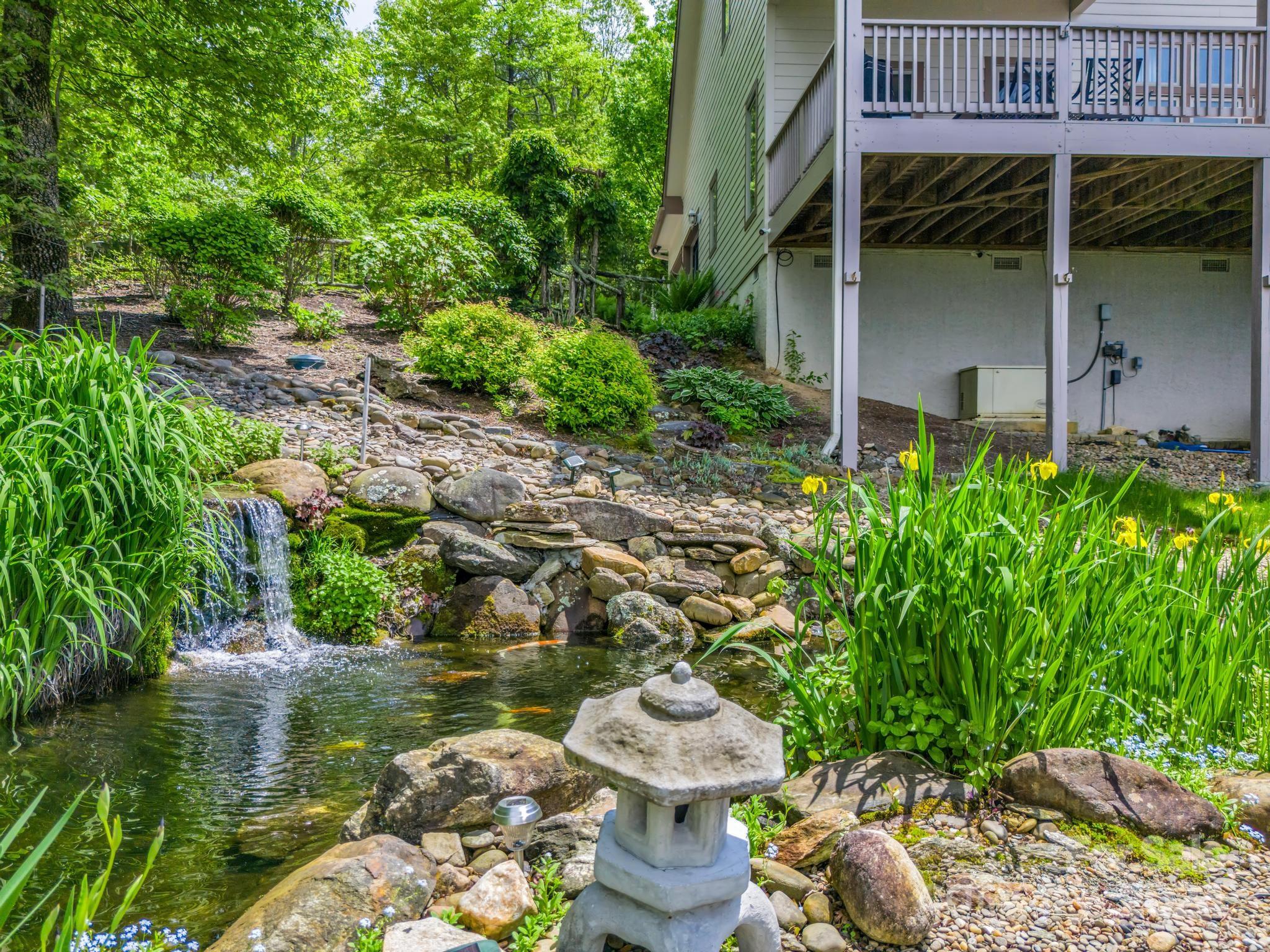 428 Devils Hole Road, Unit 14 Rosman, NC 28772 - Photo 45 of 47 a backyard of a house with lots of green space and fountain