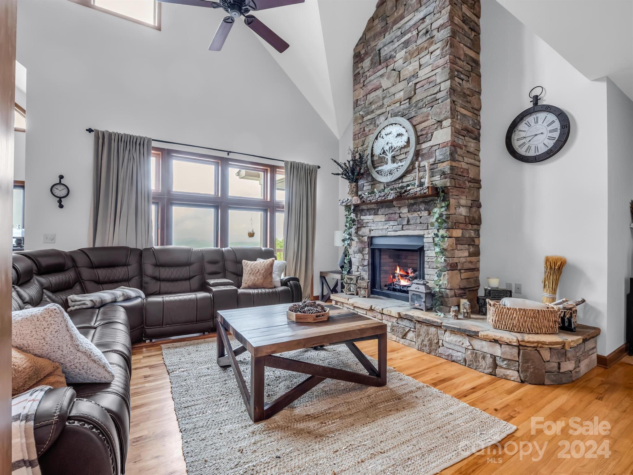 428 Devils Hole Road, Unit 14 Rosman, NC 28772 - Photo 9 of 47 a living room with furniture a clock and a large window