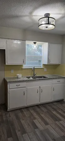 a view of a kitchen with wooden floor and a sink