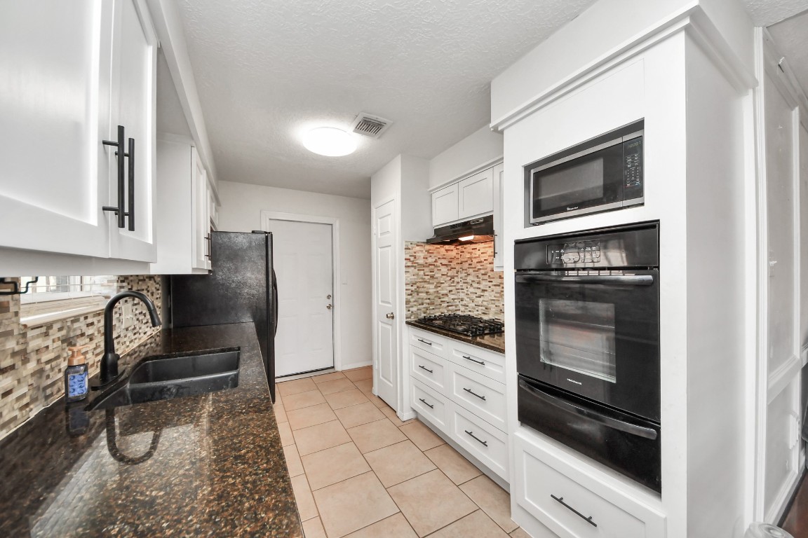 1415 Parry-Sound Pasadena, TX 77504 - Photo 16 of 39 a kitchen with granite countertop a refrigerator and a stove