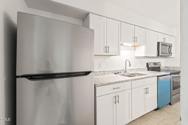 a kitchen with stainless steel appliances white cabinets and a refrigerator