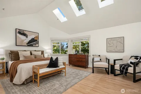 a bedroom with a bed a bookshelf a desk and chair with window