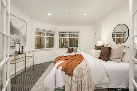 a bedroom with a bed and a large window