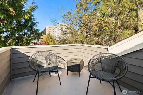 a view of a chairs and table in the balcony