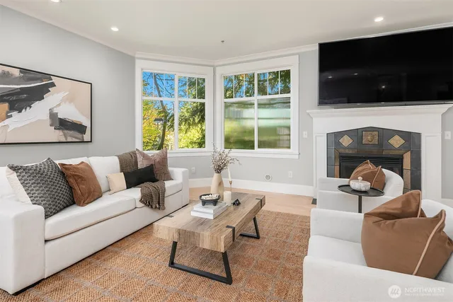 a living room with furniture a flat screen tv and a fireplace