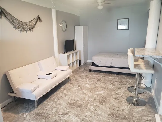 a spacious bedroom with a bed and a flat screen tv