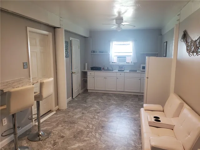 a room with a refrigerator and a dresser