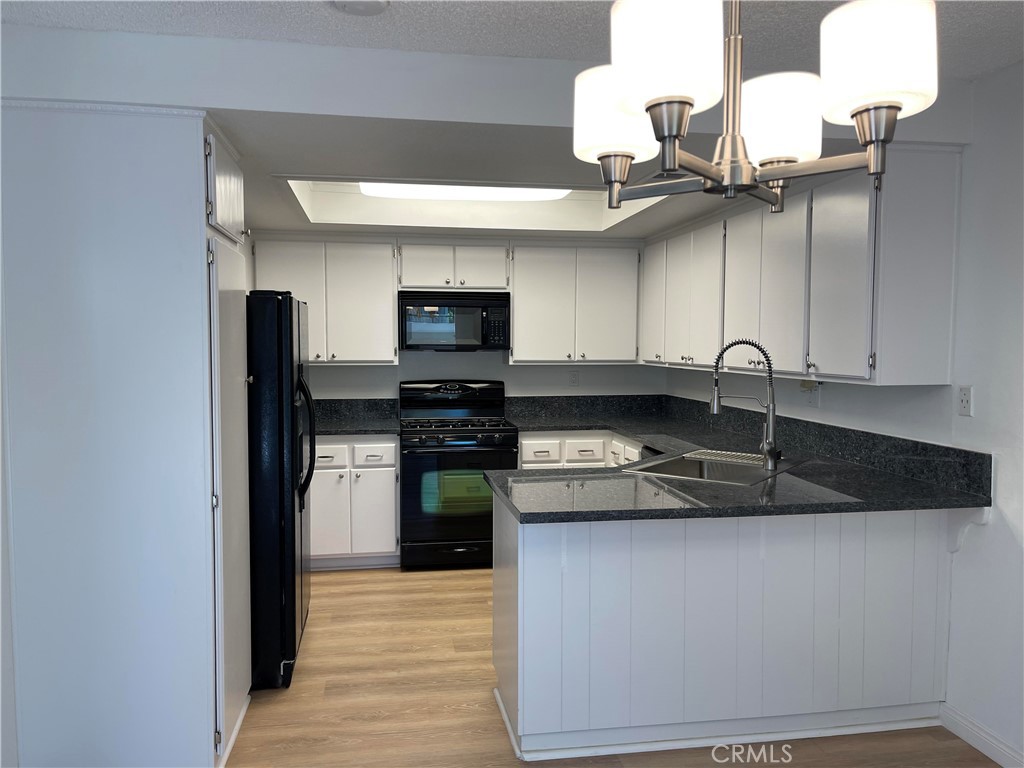 26445 Dunsmore, Unit 2 Lake Forest, CA 92630 - Photo 11 of 36 a kitchen with stainless steel appliances granite countertop a sink and a stove