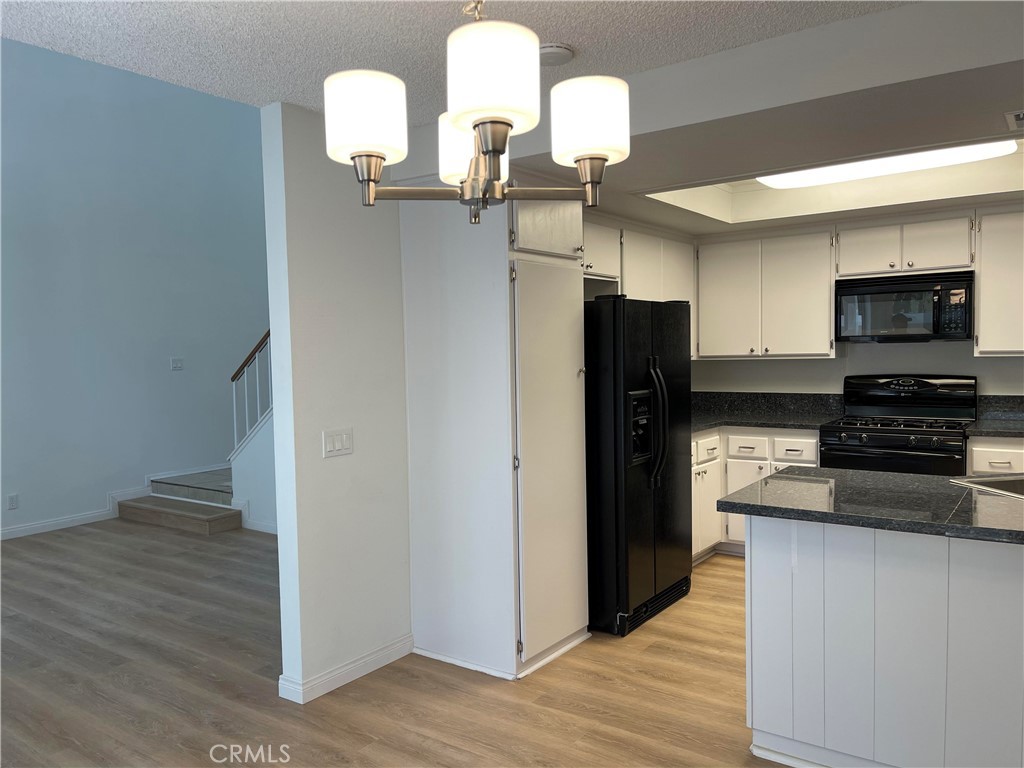 26445 Dunsmore, Unit 2 Lake Forest, CA 92630 - Photo 14 of 36 a kitchen with stainless steel appliances granite countertop a refrigerator and a stove top oven