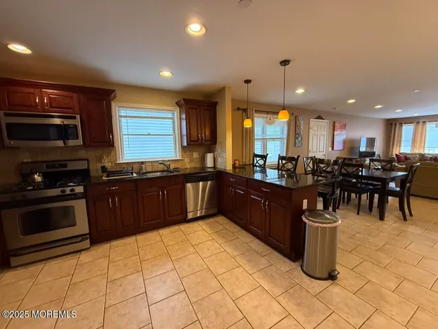 a kitchen with stainless steel appliances kitchen island granite countertop a stove and cabinets