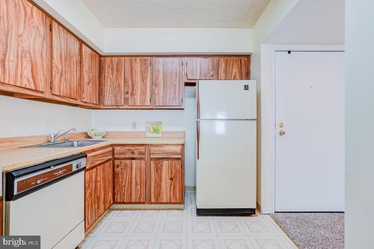 2921 North Leisure World Boulevard, Unit 1226 Silver Spring, MD 20906 - Photo 7 of 34 a kitchen with stainless steel appliances granite countertop a refrigerator sink and cabinets