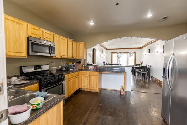 a kitchen with stainless steel appliances granite countertop a refrigerator a stove top oven a sink and dishwasher