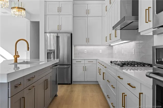 a kitchen with white cabinets and appliances