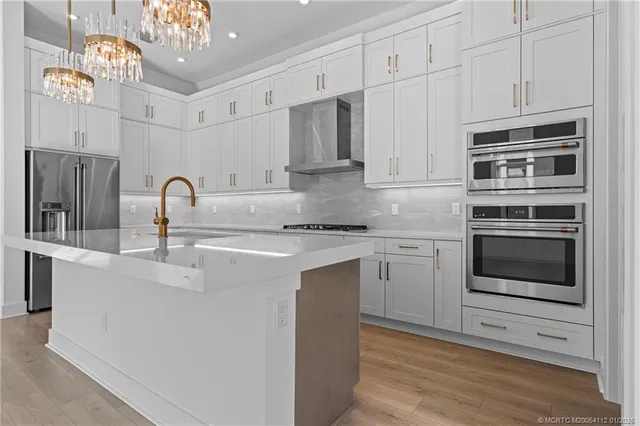 a kitchen with stainless steel appliances granite countertop a stove and white cabinets