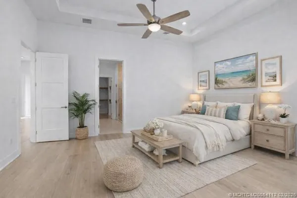 a spacious bedroom with a bed and a ceiling fan