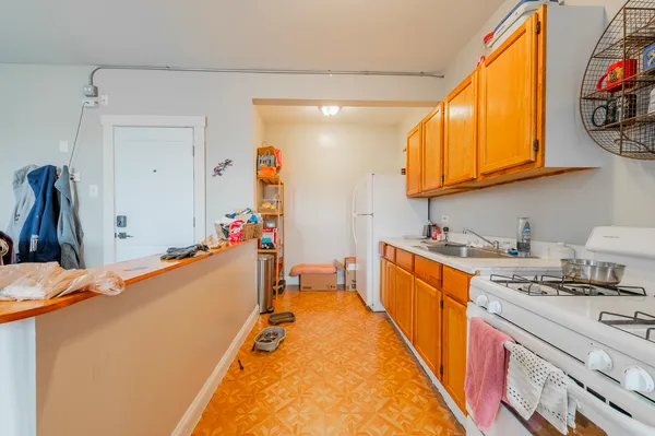 a large kitchen with stainless steel appliances granite countertop a lot of cabinets and wooden floor