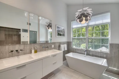 a bathroom with a large tub sink and large window