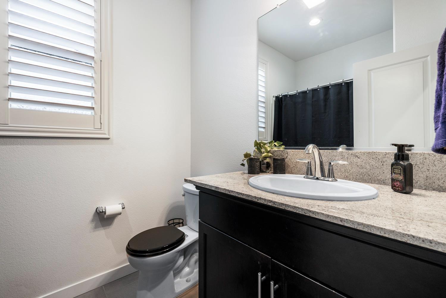 4286 Oak Knoll Road Madera, CA 93636 - Photo 17 of 43 a bathroom with a granite countertop sink and a toilet