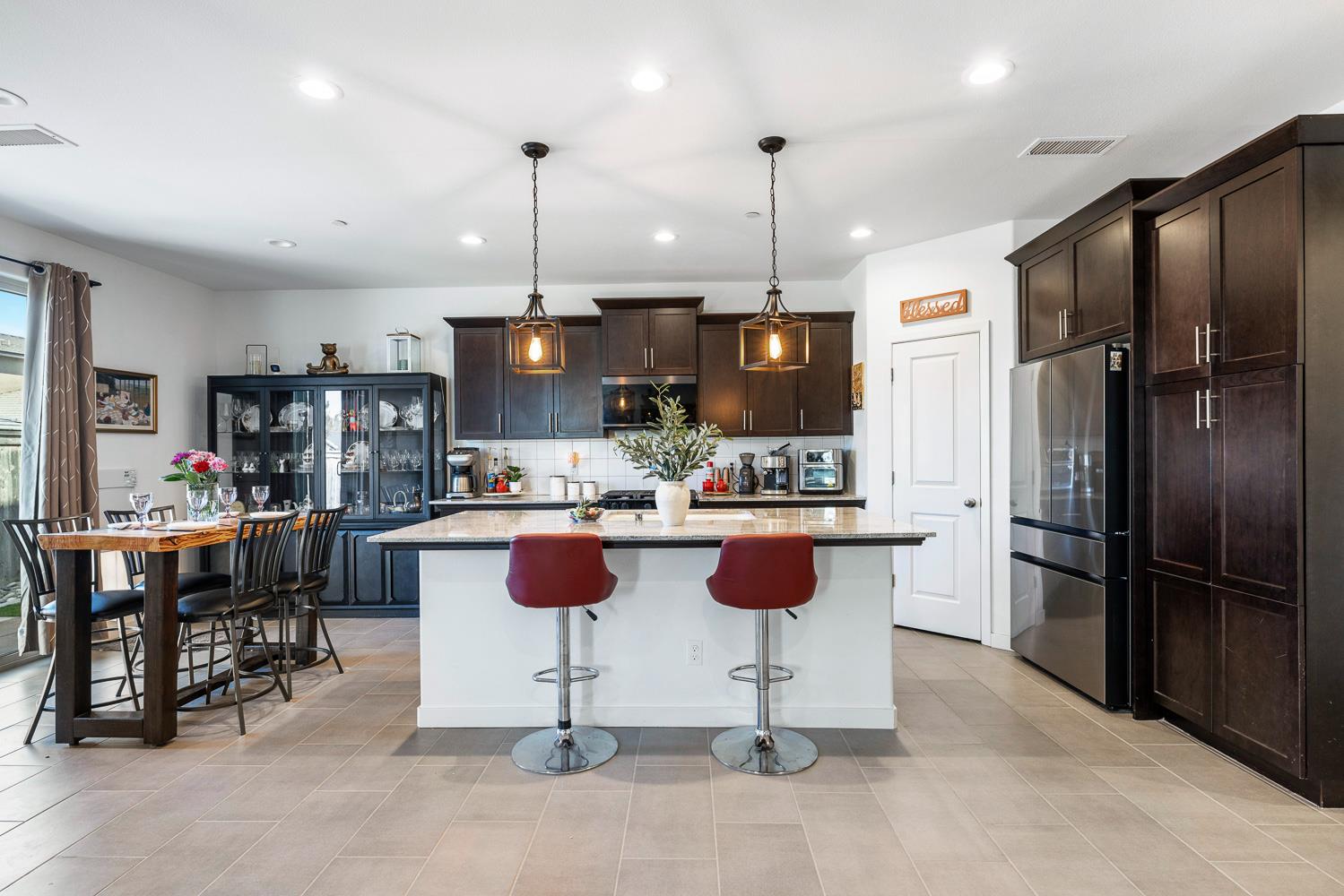4286 Oak Knoll Road Madera, CA 93636 - Photo 6 of 43 a kitchen with a refrigerator and chairs
