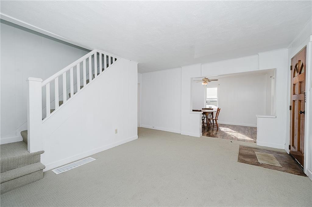 349 Adams Street Clymer, PA 15728 - Photo 21 of 36 a view of an empty room with stairs and a living room