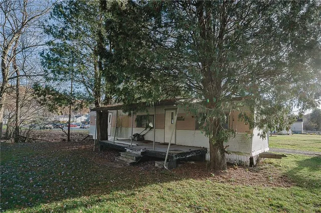 a backyard of a house with barbeque oven and trees