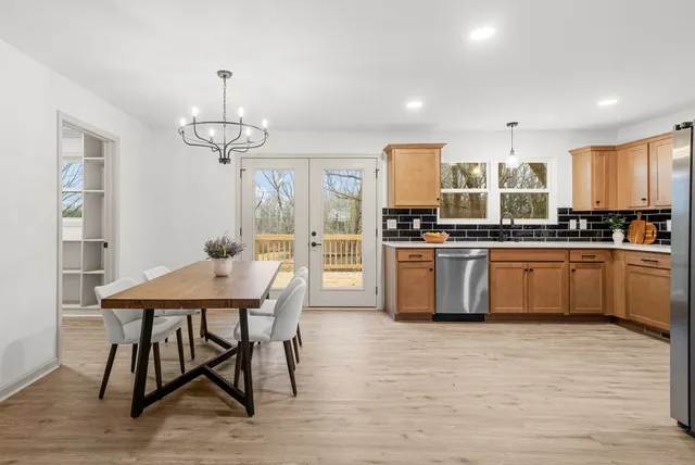 a large kitchen with sink a refrigerator and wooden floor