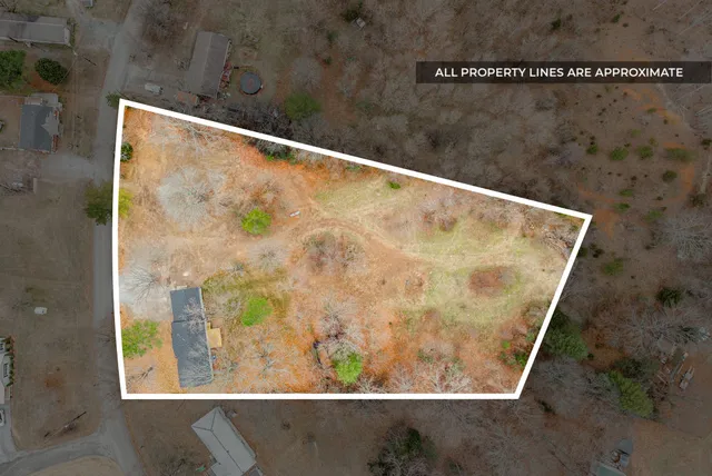 a view of a yard in front of a house with large windows