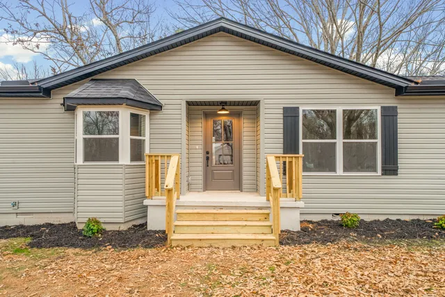 a living room with stainless steel appliances furniture a refrigerator and a kitchen counter top