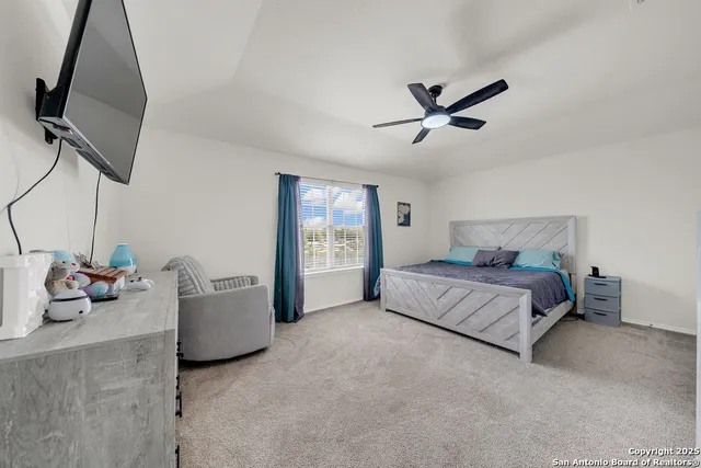 a spacious bedroom with a bed and a chandelier