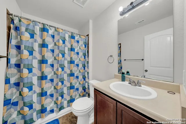 a bathroom with a sink toilet and shower curtain