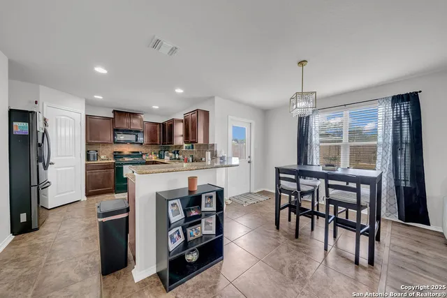 a kitchen with kitchen island wooden cabinets and refrigerator