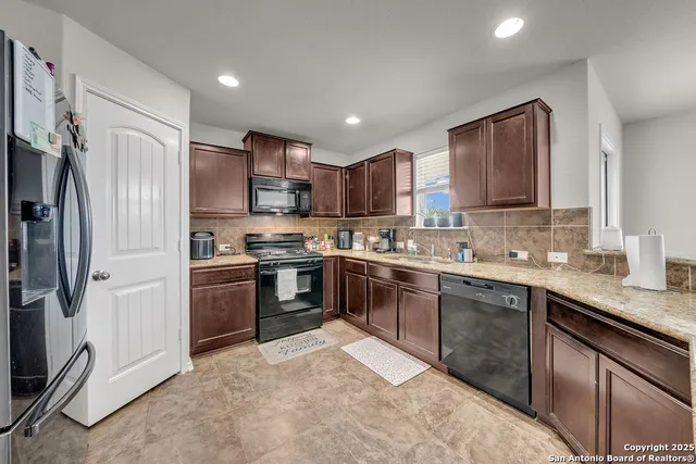 a kitchen with stainless steel appliances granite countertop a refrigerator stove and sink