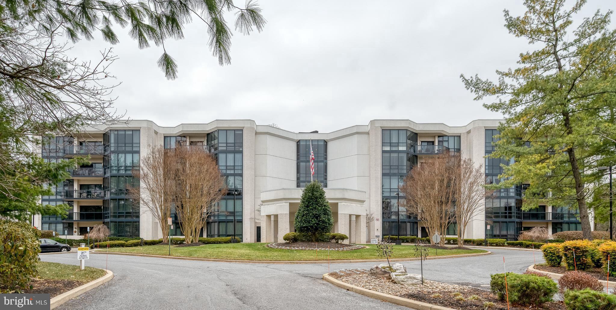 a front view of a building with a garden and plants