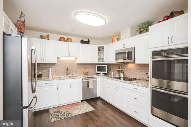 a kitchen with a sink a refrigerator and cabinets