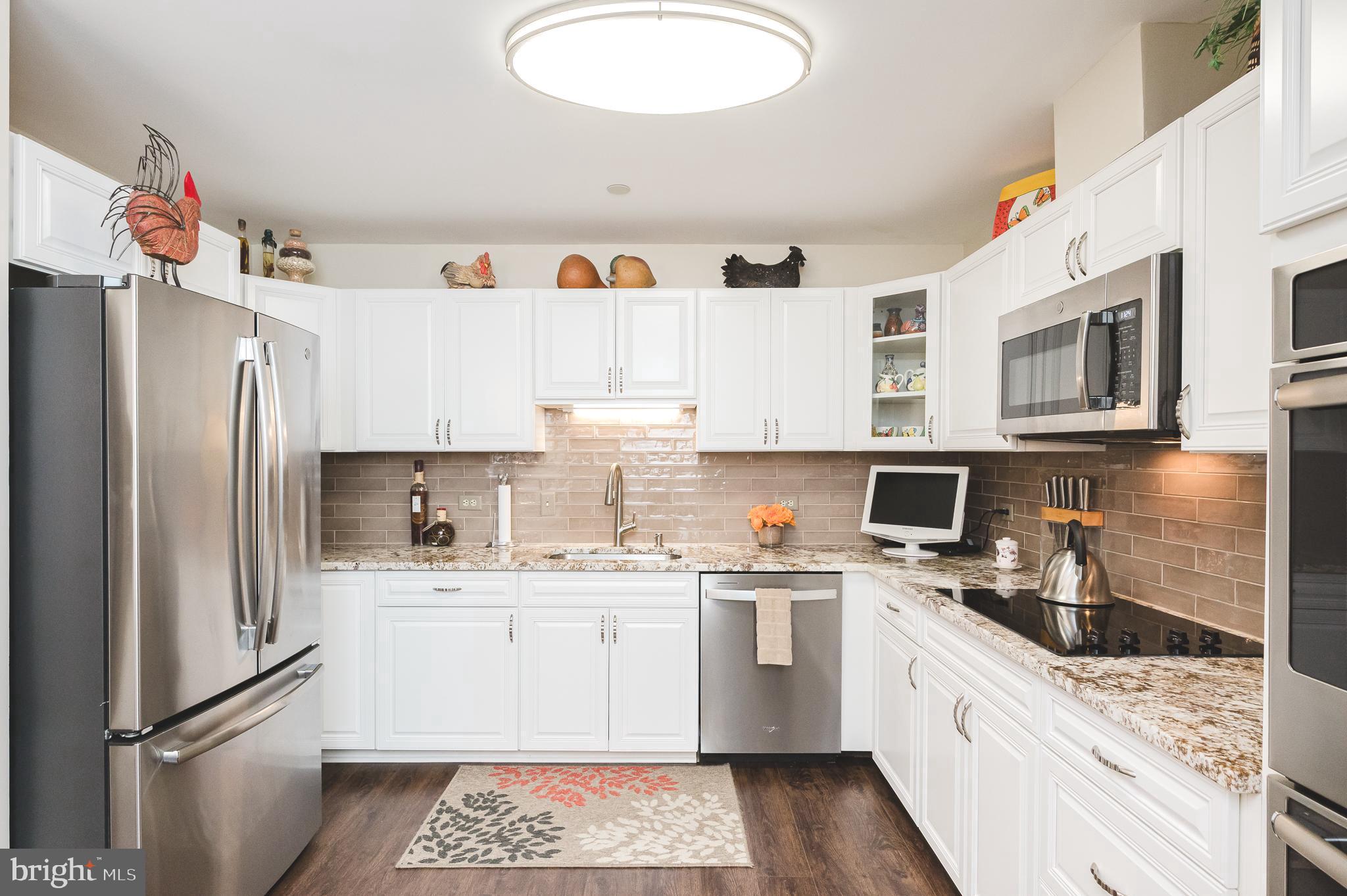 4001 Old Court Road, Unit 218 Baltimore, MD 21208 - Photo 3 of 44 a kitchen with a sink a refrigerator and cabinets