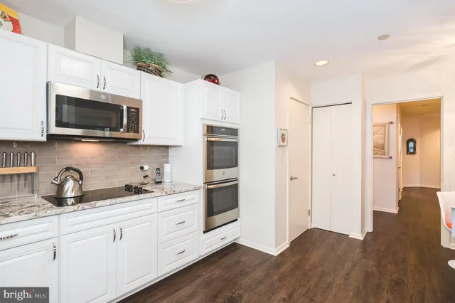 a kitchen with stainless steel appliances white cabinets a sink and a microwave