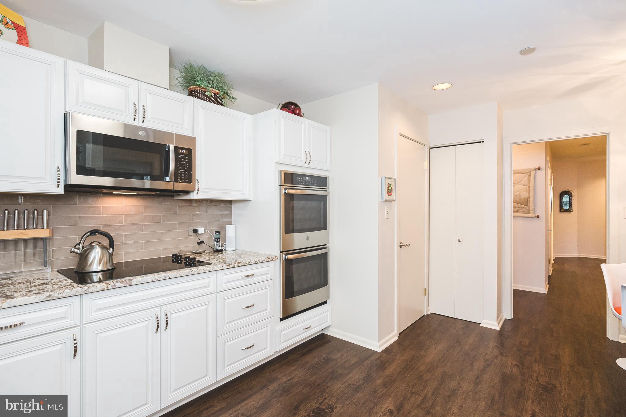 4001 Old Court Road, Unit 218 Baltimore, MD 21208 - Photo 4 of 44 a kitchen with stainless steel appliances white cabinets a sink and a microwave