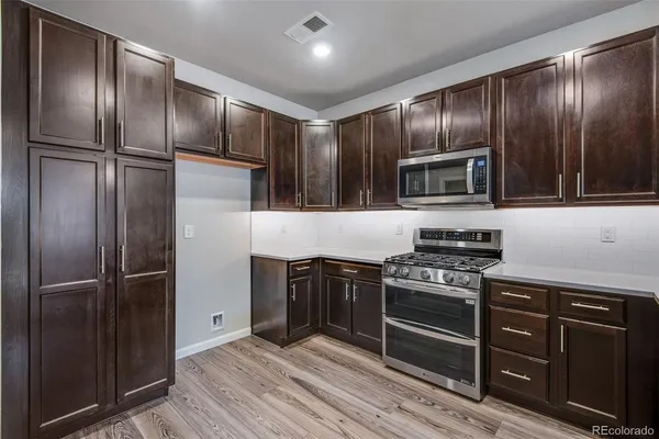 a kitchen with granite countertop stainless steel appliances and wooden cabinets