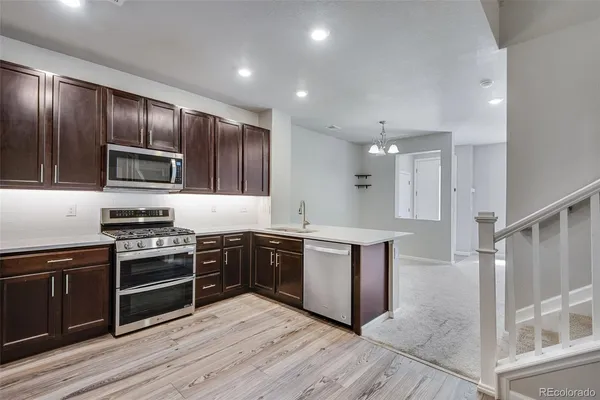 a kitchen with stainless steel appliances granite countertop wooden cabinets stove top oven and sink