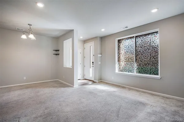 an empty room with a window and a ceiling fan
