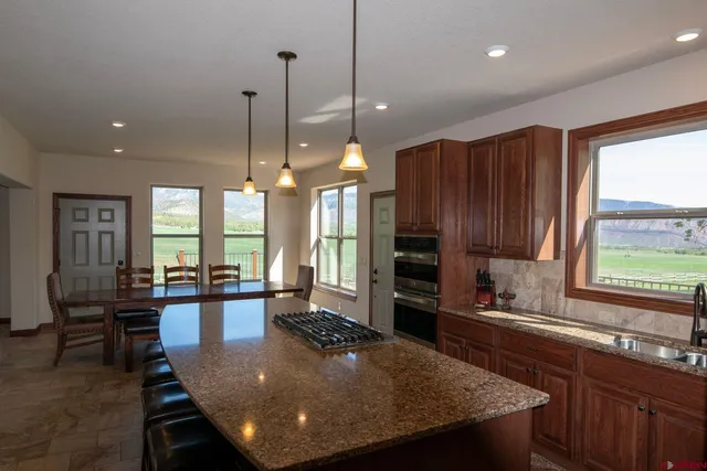 a large kitchen with kitchen island a large window in it