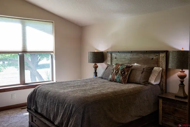 a bed sitting in a bedroom next to a window