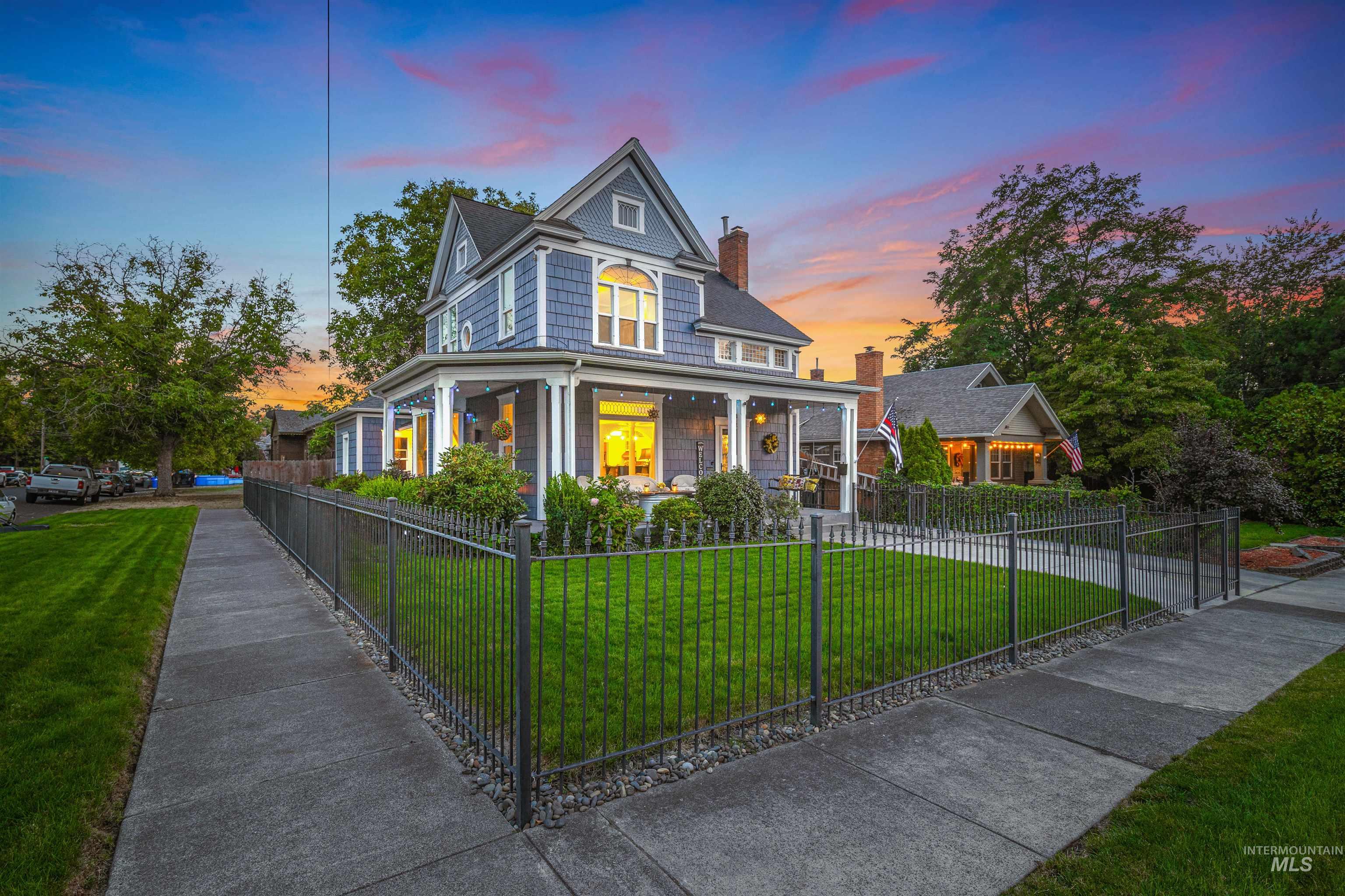 View of front of property featuring a porch, a chimney, and a fenced front yard