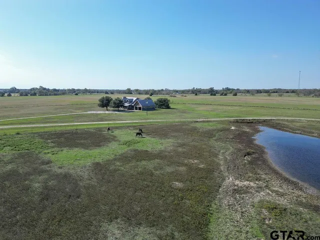 a view of a garden with a bench and lake view