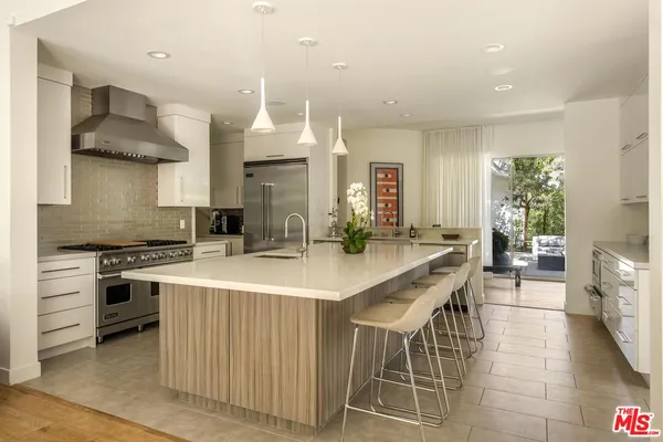 a kitchen with stainless steel appliances granite countertop a sink and a refrigerator
