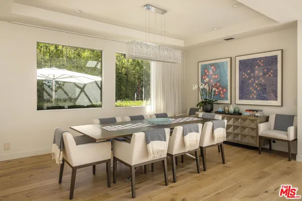 a kitchen with stainless steel appliances a stove a sink a oven a dining table and chairs