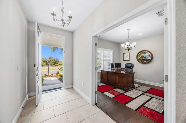 a kitchen with stainless steel appliances granite countertop a dining table chairs refrigerator and cabinets